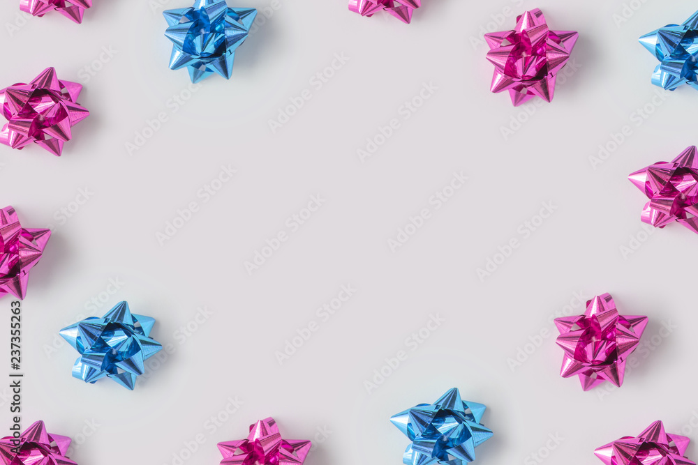 Minimal composition background of plastic pink and blue decorative Christmas gift bows. New Year concept.