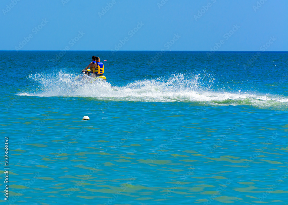 Odessa, Ukraine - August 8, 2018. Tourists having fun and enjoy riding a scooter on the sea with pleasure. Two people on a water scooter. The concept of summer vacation, vacation and travel. Odessa, Ukraine - August 8, 2018. Tourists having fun and enjoy riding a scooter on the sea with pleasure. Two people on a water scooter. The concept of summer vacation, vacation and travel.