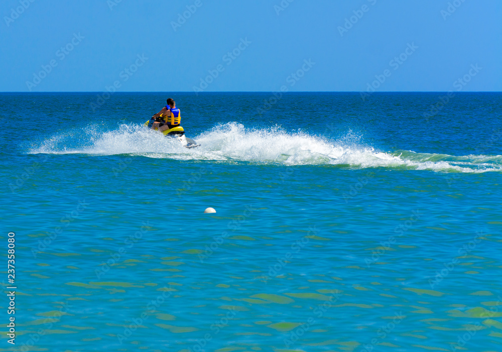 Odessa, Ukraine - August 8, 2018. Tourists having fun and enjoy riding a scooter on the sea with pleasure. Two people on a water scooter. The concept of summer vacation, vacation and travel.