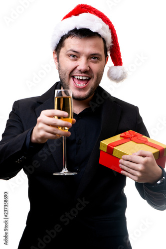 Photo of man in Santa hat with gift and glass of champagne in hands