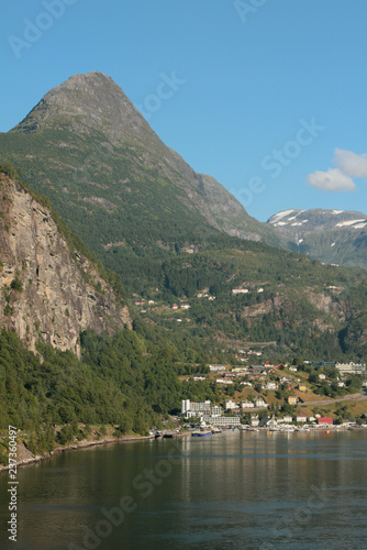 Settlement on sea coast at foot of mountains. Geiranger, Norway