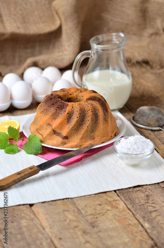 Homemade lemon bundt cake with lemon, melissa, milk, eggs and tea photo