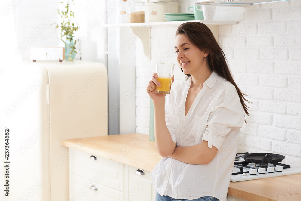 Young happy woman drinking coffee on the kitchen in the morning. Young happy woman drinking coffee on the kitchen in the morning.