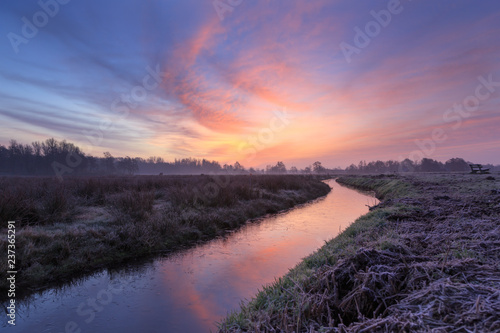 Tranquil  pink dawn at a ditch in the Dutch countryside. Groningen  Holland.