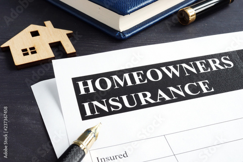 Photos Homeowners insurance policy and model of home.