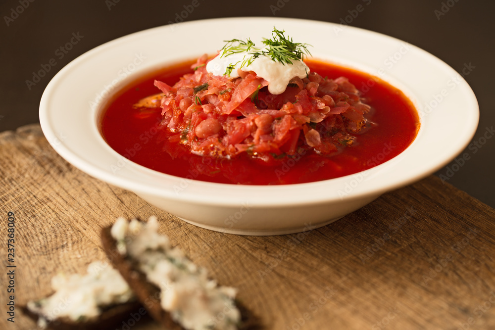 Borscht in white plate, traditional Ukrainian beet soup Borscht in white plate, traditional Ukrainian beet soup
