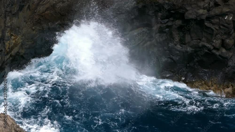 Big waves crashing on a cliff of rocks dark of lava on the coast of the island of Big waves crashing on a cliff of rocks dark of lava on the coast of the island of