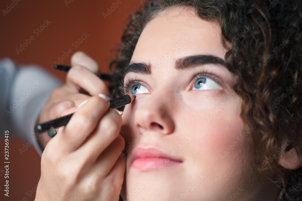 Obraz premium Closeup portrait of beautiful woman getting professional make-up with brush. Beauty and makeup concept