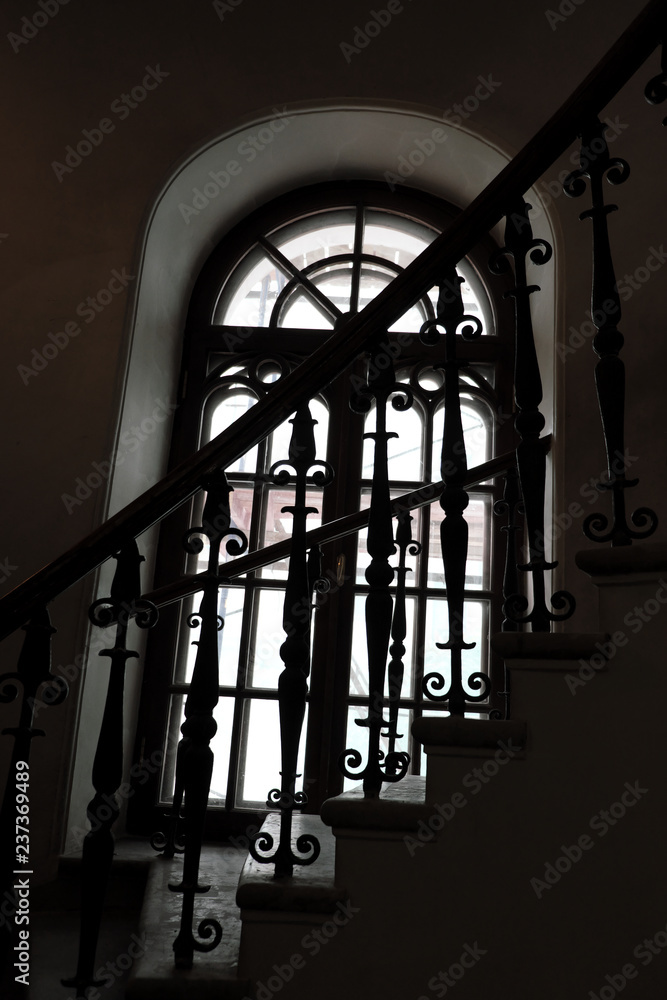 Circular spiral staircase in the tower and a tall gothic window.