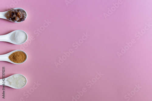 Various types of sugar, brown sugar and white on pink background. Copy space
