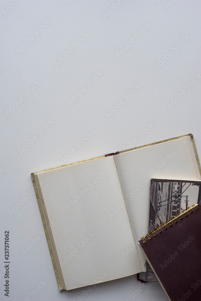 Bright beige paper notepad mockup with notepads at white table background, flat lay top view Bright beige paper notepad mockup with notepads at white table background, flat lay top view
