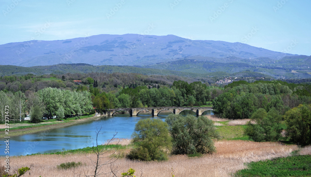Tuscany, landscape of countryside near Arezzo with the Arno river and the  Ponte a Buriano bridge in the distance