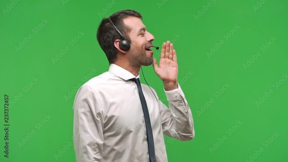 telemarketer man shouting to the lateral and announcing something on green screen chroma key background telemarketer man shouting to the lateral and announcing something on green screen chroma key background
