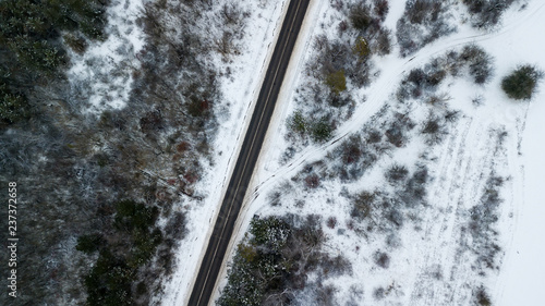 Aerial drone view of road in idyllic winter landscape.