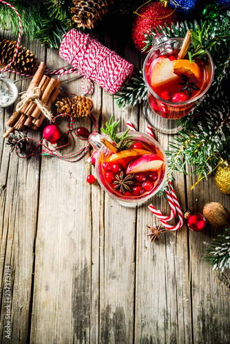 Traditional Christmas Mulled wine, grog or hot spicy sangria cocktail, on old rustic wooden table with christmas decorations and fir tree branches copy space top view