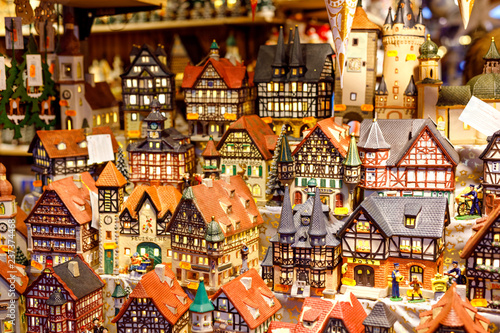 Different decoration, toy for xmas tree on christmas market, close up of cozy handmade houses, churches and castles. German traditional craft