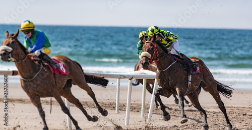 Horse racing action on the beach. competing for position on the turn
