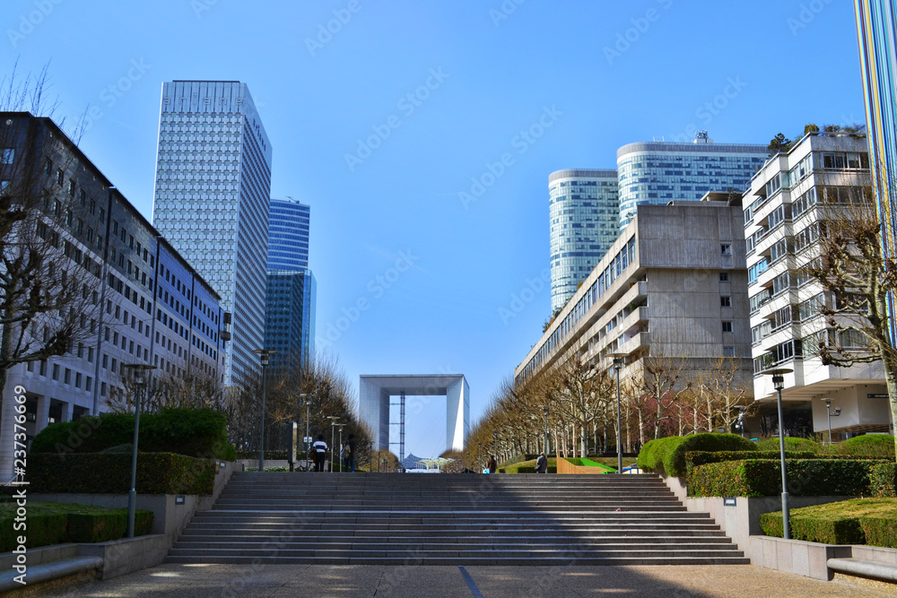 Fototapeta premium View of the promenade in the district of La Defense in Paris. Modern skyscrapers, blue sky, stairs.