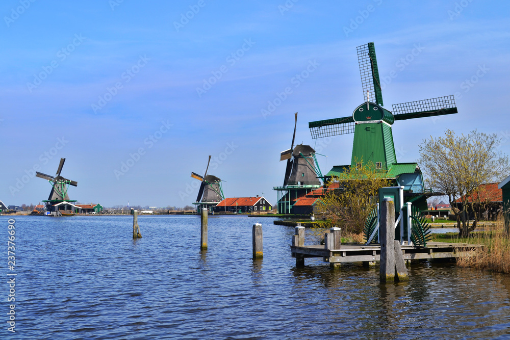 Green windmills in Zaanse Schans near the river Zaan. Zaanse Schans, The Netherlands.
