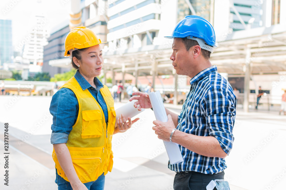 Construction and engineer concept. Construction worker in protective uniform meeting for architectural project working with partner. Worker and customer having agreement in factory. Construction and engineer concept. Construction worker in protective uniform meeting for architectural project working with partner. Worker and customer having agreement in factory.