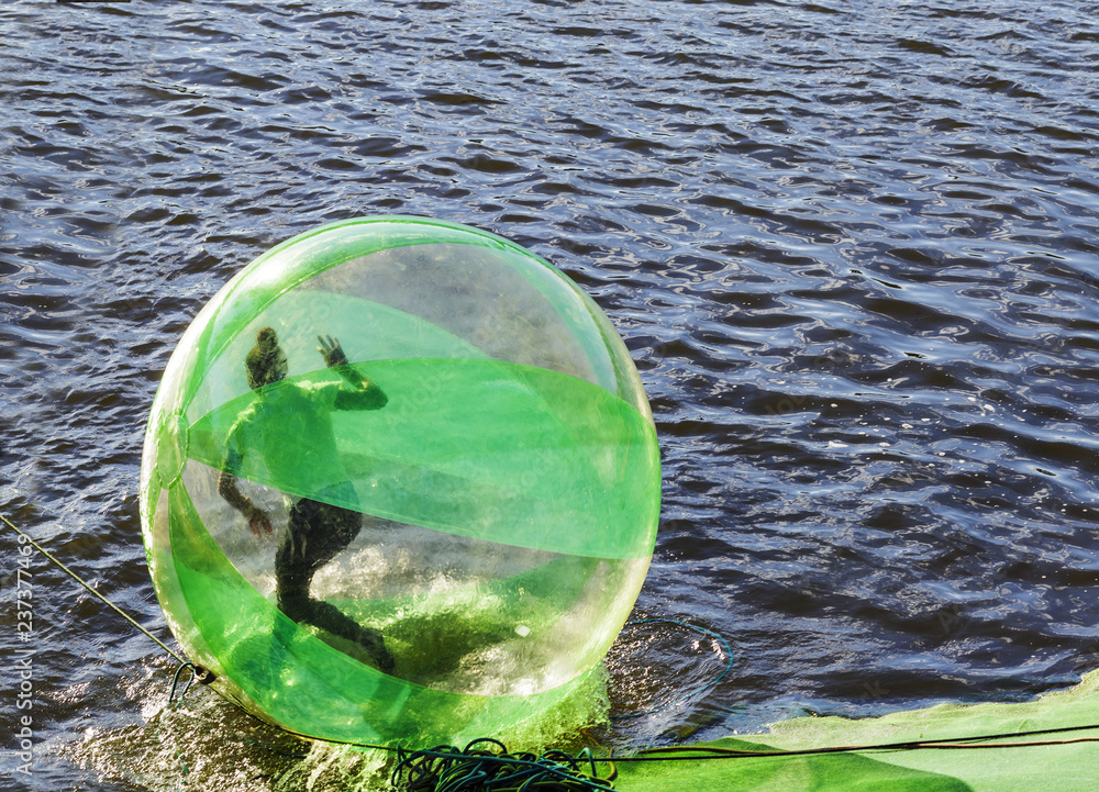 Φωτογραφία Young woman in water ball (similar to zorb or Human Hamster Ball) on river surface