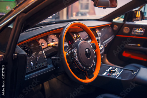 Close up Luxury convertible car interior. Steering wheel, shift lever and dashboard. Driver side view. Selective focus, copy space.
