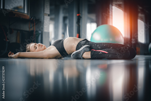 Young attractive woman fitness exercise workout in gym. Woman stretching the muscles and relaxing after exercise at fitness gym club. photo