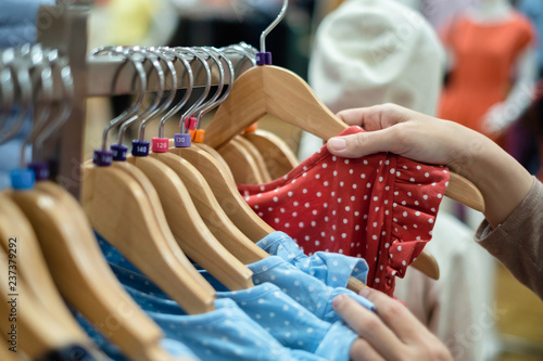 A women is choosing new clothes, shopping in fashion mall, close up of hands