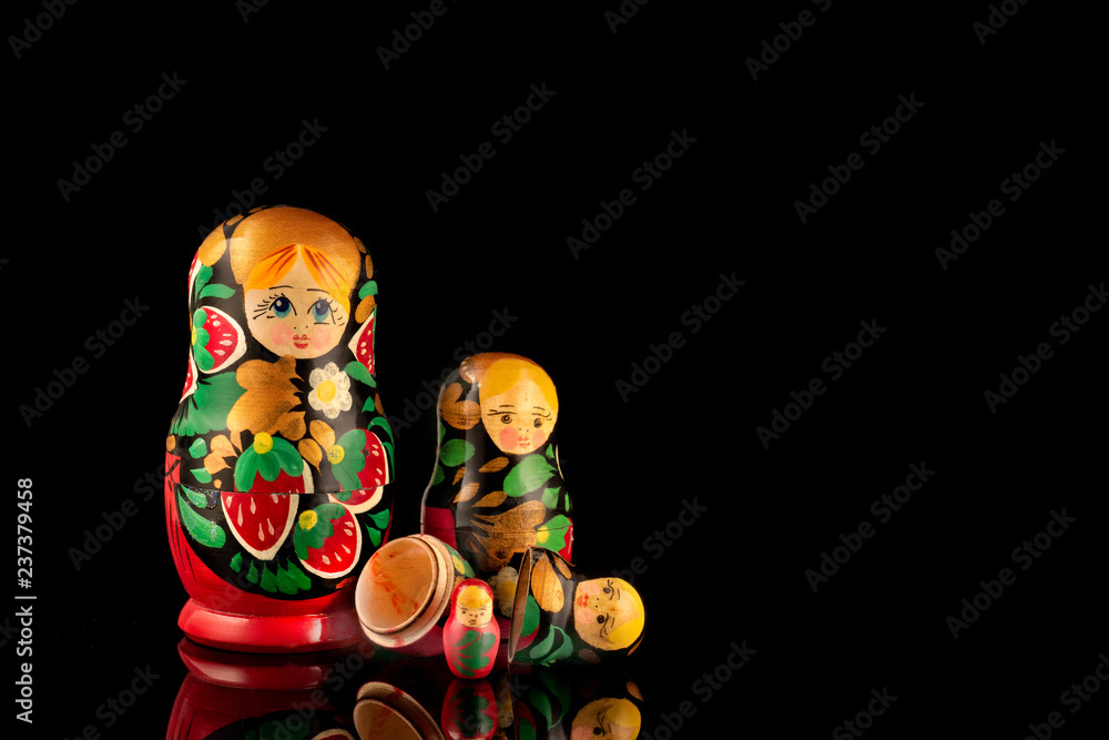 Group of wooden nesting dolls from the USSR on a black background. Traditional Russian souvenir - matryoshka (matrioshka).