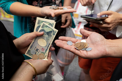 Photography tourist hand and japanese yen banknote in traveling shopping area