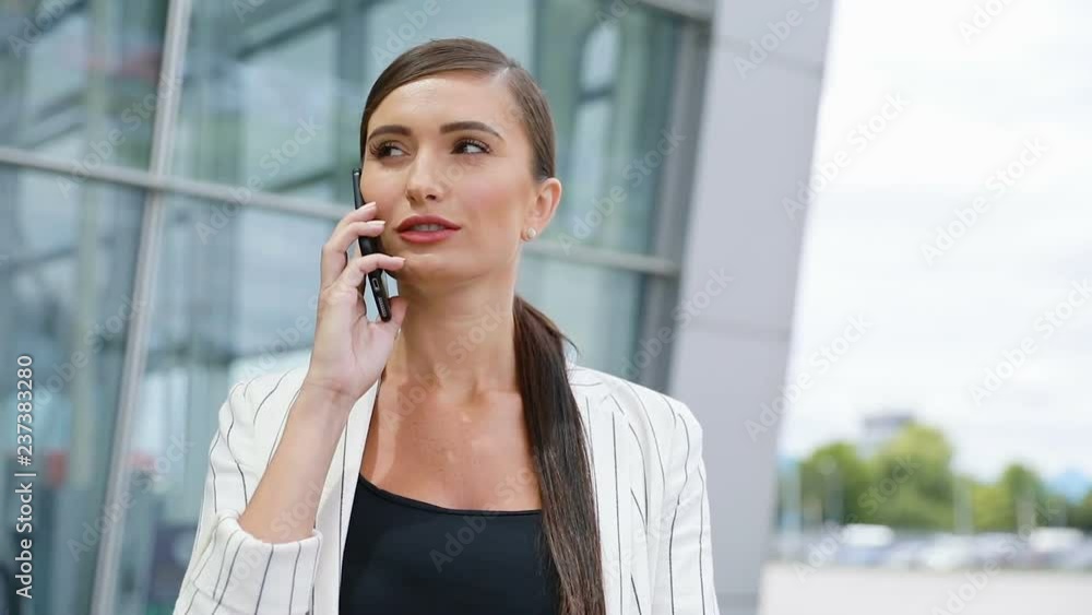 Beautiful Smiling Woman Talking On Phone Near Business Office Beautiful Smiling Woman Talking On Phone Near Business Office