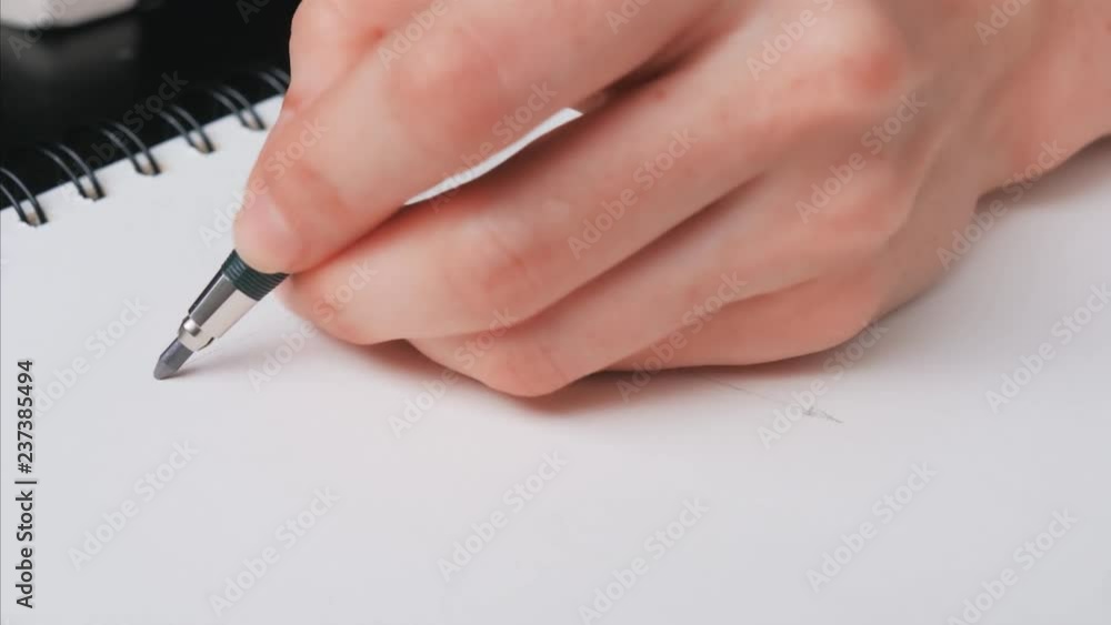 Hand holding a pencil and ready to drawing on notebook Hand holding a pencil and ready to drawing on notebook
