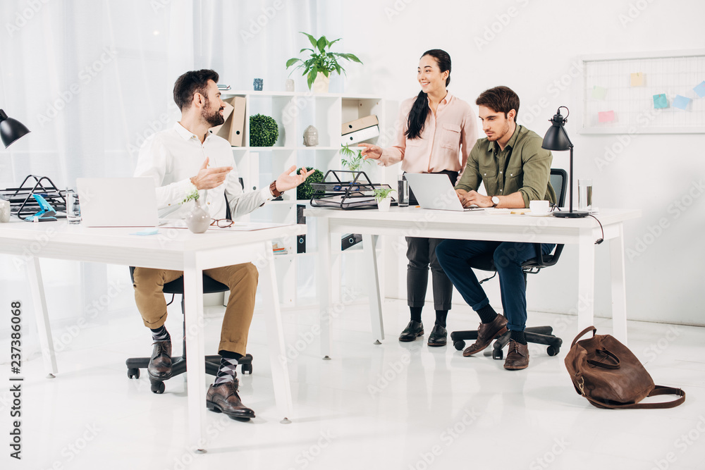 Obraz premium Office colleagues smiling and talking in modern office