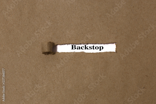 Ripped brown manilla envelope revealing the word backstop on white paper. UK Brexit deal concept