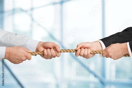 Business men hands holding rope on grey background