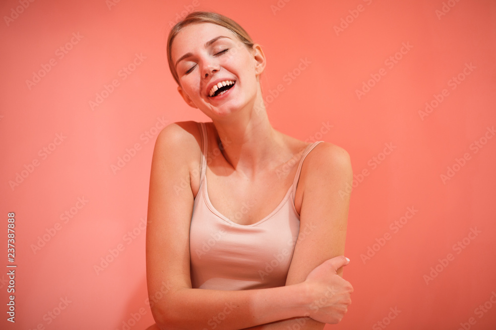 Obraz premium Portrait of laughing happy female model in pink background.