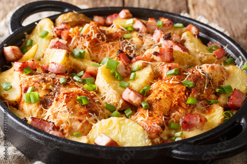 Chicken fillet casserole with potatoes, bacon and cheese close-up in a frying pan. horizontal