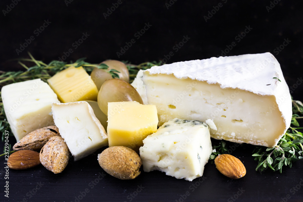 Fototapeta premium Tasty food background. Cheese with grapes, almond and thyme.