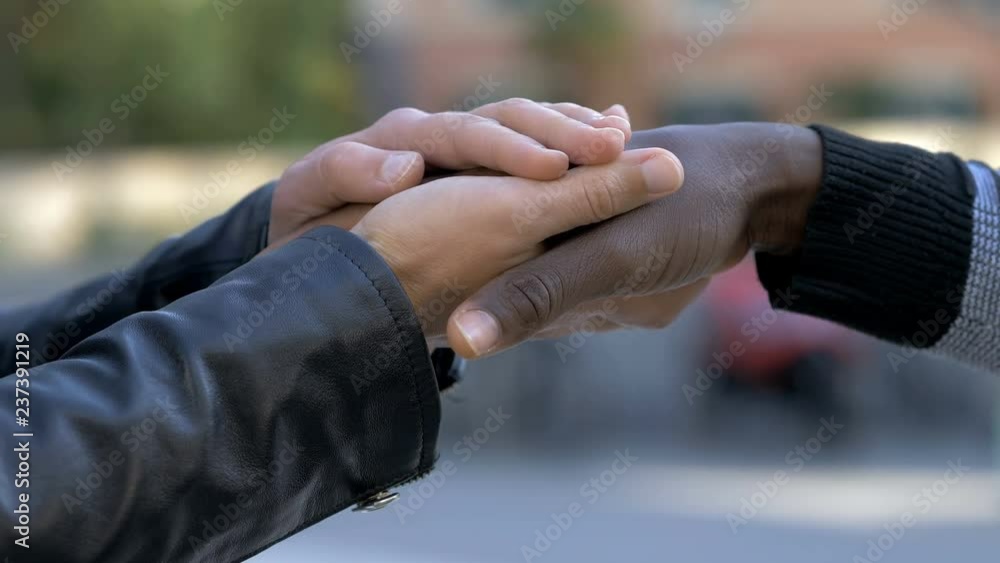 White hands holding black man hands. Fraternity,Interracial friendship-outdoor White hands holding black man hands. Fraternity,Interracial friendship-outdoor