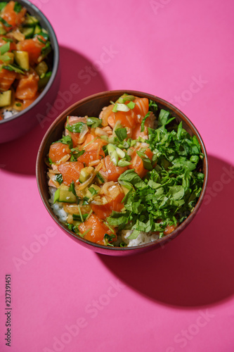 Poke bowl with marinated salmon and vegetable salad on rice