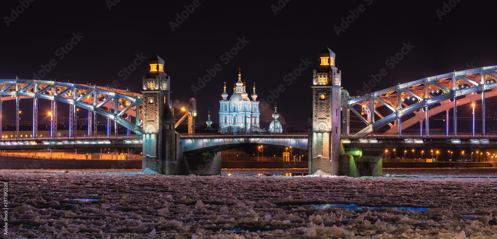 Saint Petersburg, Russia. Christmas Night View At Neva River During Freezing, Peter the Great Bridge ( Also Known As Bolsheokhtensky Or Okhtinsky Bridge ) And The Smolny Cathedral With Golden Domes