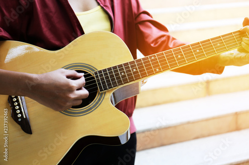 Close up beautiful woman playing acoustic guitar.