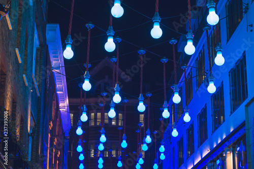 Blue colored Christmas lights shaped like bulbs hanging from above Carnaby Street London