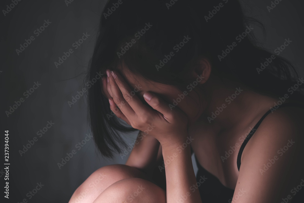 Sad depressed woman suffering from family life. women sitting in dark room cryng, palm close her face. Young beautiful women thinking how to solve problem. Sad depressed woman suffering from family life. women sitting in dark room cryng, palm close her face. Young beautiful women thinking how to solve problem.