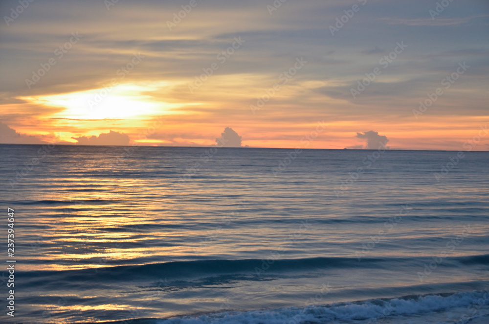 A golden scene of sunset reflection on the Haad Son beach, Khao Lak, Phang Nga, Thailand during summer time.