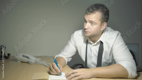 The guy detective in a white shirt listens to the interlocutor with a surprised face in his office