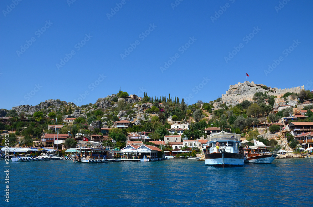 Cute houses on the south coast of Turkey. View from the sea to the pier, near the island of Kekova.