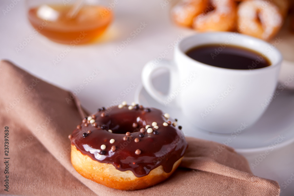 Fresh chocolate donut with cup of coffee on the table Fresh chocolate donut with cup of coffee on the table