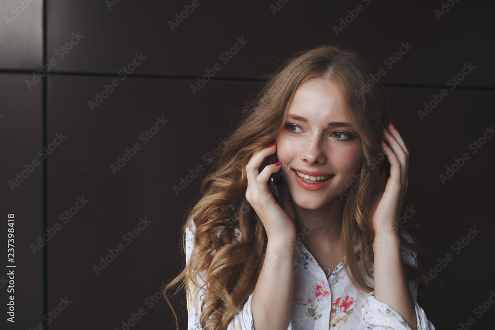 Fototapeta premium Young charming woman calling with cell phone,, attractive woman with cute smile talking with mobile phone while relaxing.closeup. business woman with