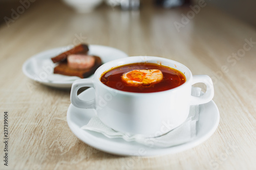 Ukrainian traditional borsch. Russian vegetarian red soup in white bowl on red wooden background. Top view. Borscht, borshch with beet